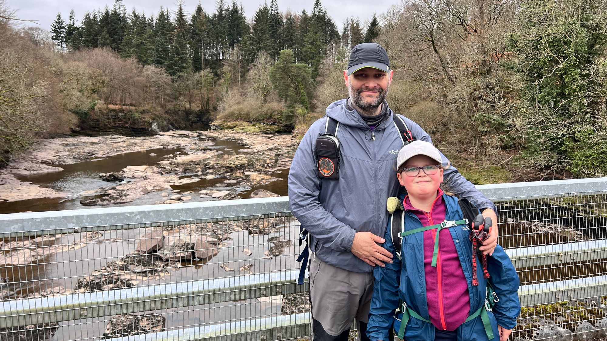 Ian and Eve standing on the bridge at the end of the Clyde Walkway with the Falls of Clyde behind us